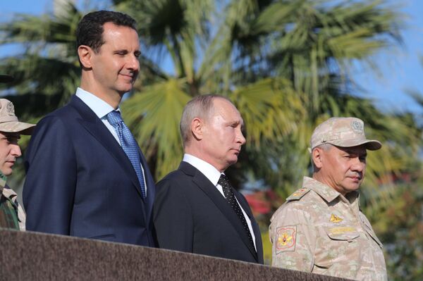 President of Russia Vladimir Putin, President of Syria Bashar al-Assad (left) and Defense Minister Sergei Shoigu at the Hmeymim Air Base in Syria - Sputnik International