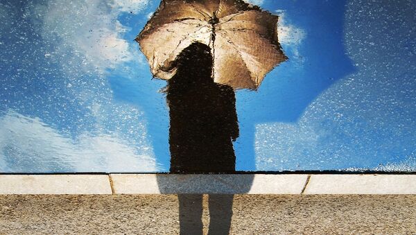 A silhouette of a woman holding an umbrella - Sputnik International