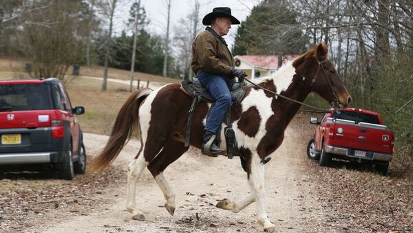 U.S. Senate Republican candidate Roy Moore rides a horse to vote, Tuesday, Dec. 12, 2017, in Gallant, Ala. - Sputnik International