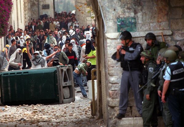 Israeli borderguards take cover from Palestinian stone-throwers in Jerusalem's Old City outside the al-Aqsa mosque compound 08 December 2000, as clashes erupted following the second Friday noon prayer in the holy month of the Ramada Israeli borderguards take cover from Palestinian stone-throwers in Jerusalem's Old City outside the al-Aqsa mosque compound 08 December 2000, as clashes erupted following the second Friday noon prayer in the holy month of the Ramada - Sputnik International