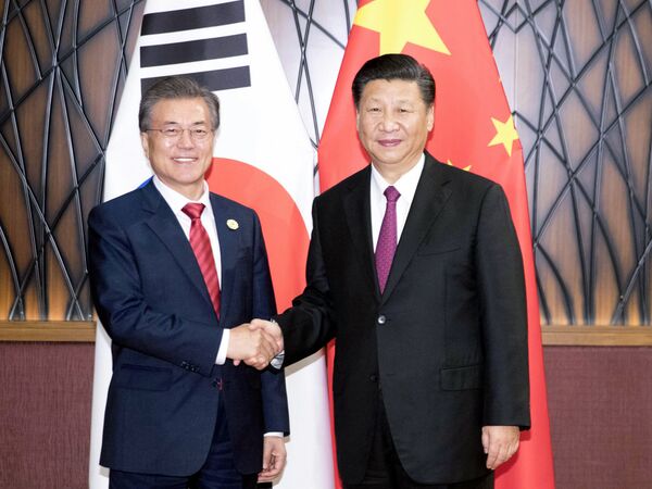 In this Nov. 11, 2017, photo released by China's Xinhua News Agency, South Korean President Moon Jae-in, left, and Chinese President Xi Jinping shake hands as they pose for a photo during a meeting on the sidelines of the Asia-Pacific Economic Cooperation (APEC) Forum in Danang, Vietnam. In this Nov. 11, 2017, photo released by China's Xinhua News Agency, South Korean President Moon Jae-in, left, and Chinese President Xi Jinping shake hands as they pose for a photo during a meeting on the sidelines of the Asia-Pacific Economic Cooperation (APEC) Forum in Danang, Vietnam. - Sputnik International