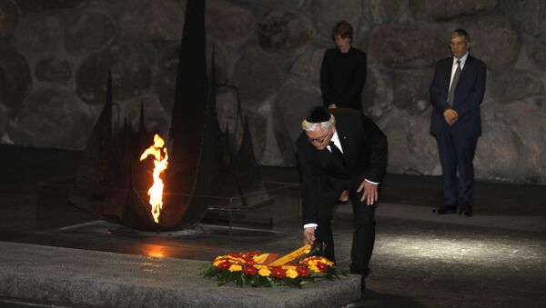 German President Frank-Walter Steinmeier (C), escorted by his wife Elke Budenbender (L) and the chairman of the Yad Vashem Holocaust Memorial museum, Avner Shalev (R), lays a wreath at the Hall of Remembrance, where the names of major death and concentration camps are written, during his visit to Yad Vashem commemorating the six million Jews killed by Nazis during World War II, in Jerusalem on May 7, 2017 - Sputnik International