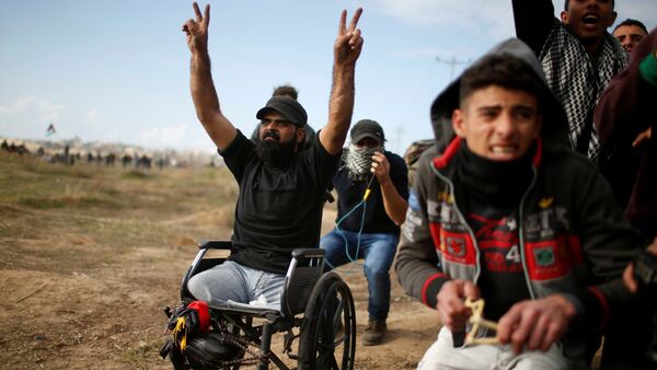 Wheelchair-bound Palestinian demonstrator Ibraheem Abu Thuraya, who according to medics was killed later on Friday during clashes with Israeli troops, gestures during a protest against U.S. President Donald Trump's decision to recognize Jerusalem as the capital of Israel, near the border with Israel in the east of Gaza City December 15, 2017 - Sputnik International