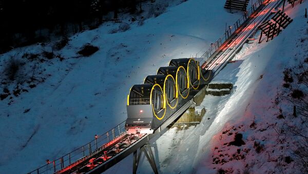 The barrel-shaped carriages of a new funicular line are seen on the illuminated track before the opening ceremony near the Alpine resort of Stoos, Switzerland December 15, 2017 - Sputnik International