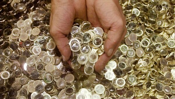 An employee of the national German mint Staatliche Muenze in Berlin holds some Euro coins on Wednesday, Aug. 29, 2001 - Sputnik International