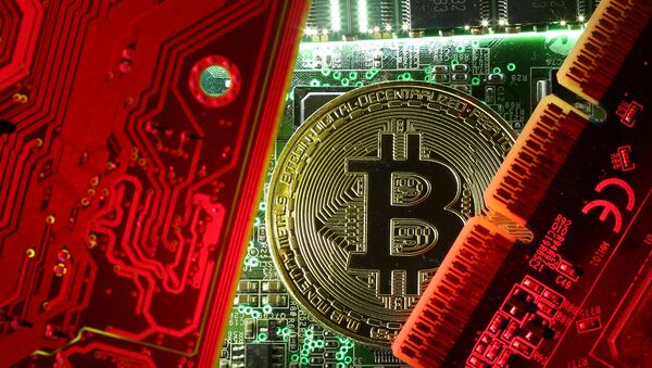 A coin representing the bitcoin cryptocurrency is seen on computer circuit boards in this illustration picture, October 26, 2017 - Sputnik International