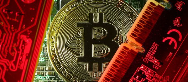 A coin representing the bitcoin cryptocurrency is seen on computer circuit boards in this illustration picture, October 26, 2017 A coin representing the bitcoin cryptocurrency is seen on computer circuit boards in this illustration picture, October 26, 2017 - Sputnik International