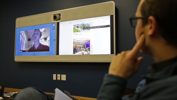 Jeff Wieland,, right, Facebook director of accessibility, watches as engineer Matt King, who is blind, demonstrates facial recognition technology via a teleconference at Facebook headquarters in Menlo Park, Calif - Sputnik International