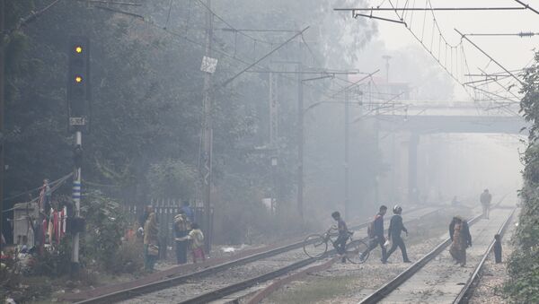 Indian residents walk amid heavy smog near the Lodhi railway station in New Delhi - Sputnik International
