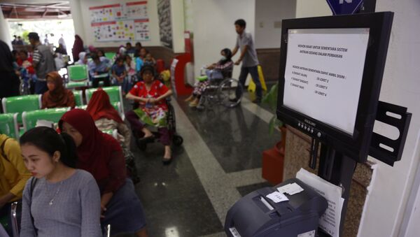 Patients wait near a queue number dispenser affected by WannaCry attack at Dharmais Cancer Hospital in Jakarta, Indonesia, Monday, May 15, 2017 - Sputnik International