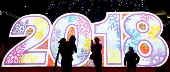 People take photos at a New Year tree installed on Oktyabrskaya Square for the upcoming New Year and Christmas season in Minsk, Belarus - Sputnik International