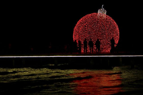 People are silhouetted on a pedestrian dock decorated with an illuminated Christmas ornament in the southern coastal city of Larnaca on the eastern Mediterranean island of Cyprus - Sputnik International