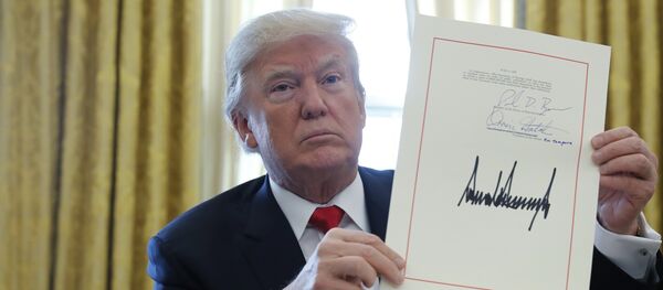 U.S. President Donald Trump displays his signature after signing the $1.5 trillion tax overhaul plan along with a short-term government spending bill in the Oval Office of the White House in Washington, U.S - Sputnik International