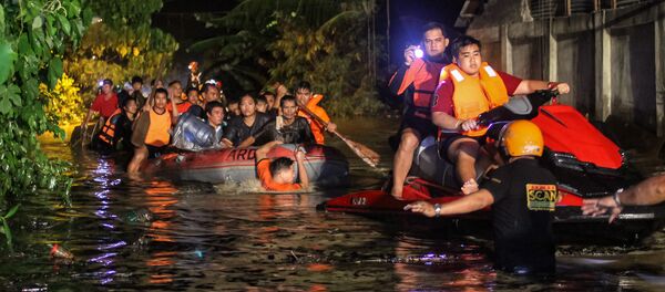 Rescue workers evacuate flood-affected residents in Davao on the southern Philippine island of Mindanao early on December 23, 2017, after Tropical Storm Tembin dumped torrential rains across the island. The death toll from the tropical storm that struck the southern Philippines has risen to 30 with five others missing, officials said on December 23 - Sputnik International