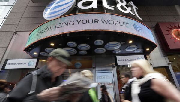 In this Oct. 21, 2014 photo, people pass an AT&T store in New York's Times Square. AT&T is being sued by the government over allegations it misled millions of smartphone customers who were promised unlimited data but had their Internet speeds cut by the company — slowing their ability to open web pages or watch streaming video. - Sputnik International