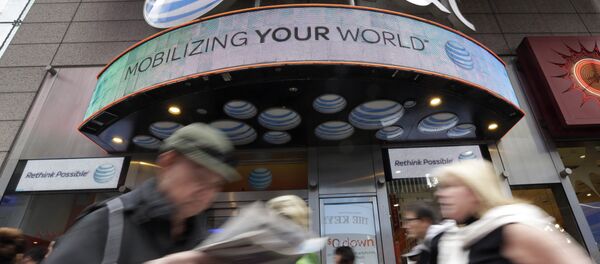 In this Oct. 21, 2014 photo, people pass an AT&T store in New York's Times Square. AT&T is being sued by the government over allegations it misled millions of smartphone customers who were promised unlimited data but had their Internet speeds cut by the company — slowing their ability to open web pages or watch streaming video. In this Oct. 21, 2014 photo, people pass an AT&T store in New York's Times Square. AT&T is being sued by the government over allegations it misled millions of smartphone customers who were promised unlimited data but had their Internet speeds cut by the company — slowing their ability to open web pages or watch streaming video. - Sputnik International