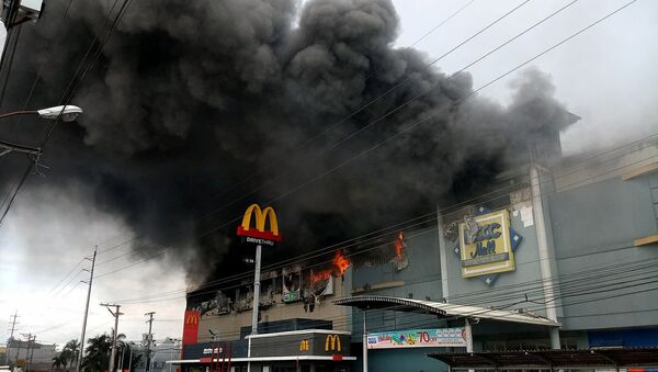 Smoke billows from a shopping mall on fire in Davao City, the Philippines, in this December 23, 2017 photo obtained from social media - Sputnik International