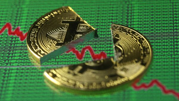 Broken representation of the Bitcoin virtual currency, placed on a monitor that displays stock graph and binary codes, are seen in this illustration picture, December 21, 2017 - Sputnik International