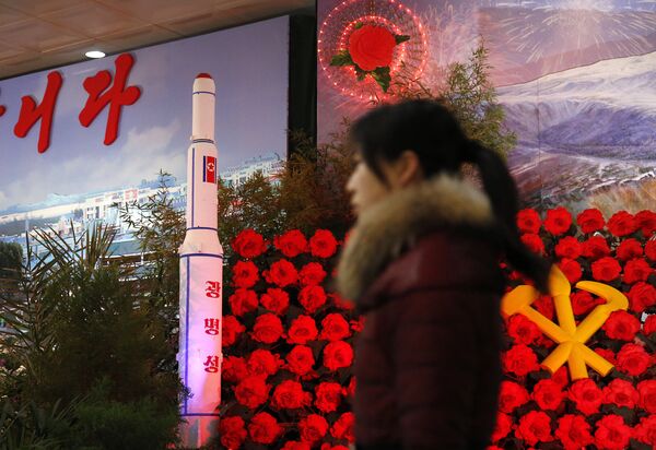 In this Feb. 15, 2016 file photo, a visitor at a flower festival walks past a model of North Korea's newest satellite Kwangmyongsong 4 on display In this Feb. 15, 2016 file photo, a visitor at a flower festival walks past a model of North Korea's newest satellite Kwangmyongsong 4 on display - Sputnik International