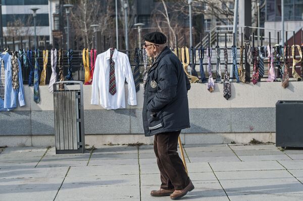 A man passes by hundreds of collected ties and shirts hanging on the fence of the government building on Tuesday, Dec. 26, 2017, in Kosovo capital Pristina A man passes by hundreds of collected ties and shirts hanging on the fence of the government building on Tuesday, Dec. 26, 2017, in Kosovo capital Pristina - Sputnik International