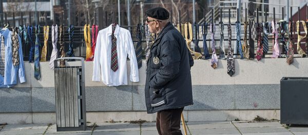 A man passes by hundreds of collected ties and shirts hanging on the fence of the government building on Tuesday, Dec. 26, 2017, in Kosovo capital Pristina A man passes by hundreds of collected ties and shirts hanging on the fence of the government building on Tuesday, Dec. 26, 2017, in Kosovo capital Pristina - Sputnik International