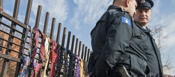 Kosovo police officers guard the entrance of prime ministers office as hundred of collected ties hung on the fence of the government building on Tuesday, Dec. 26, 2017, in Kosovo capital Pristina - Sputnik International
