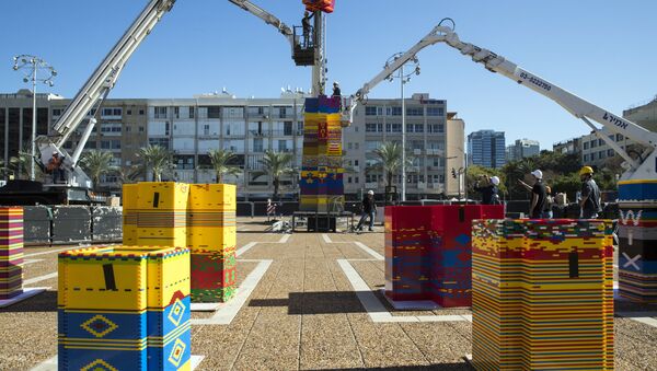 Workers and volunteers help assemble bricks during the construction of a LEGO tower in Tel Aviv's Rabin Square on December 26, 2017, as the city attempts to break Guinness world record of the highest such structure - Sputnik International