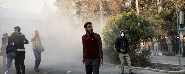 Iran, university students attend a protest inside Tehran University while a smoke grenade is thrown by anti-riot Iranian police, in Tehran, Iran, Saturday, Dec. 30, 2017 Iran, university students attend a protest inside Tehran University while a smoke grenade is thrown by anti-riot Iranian police, in Tehran, Iran, Saturday, Dec. 30, 2017 - Sputnik International