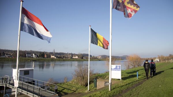 People walk past Dutch and Belgian flags on the waterfront in Eijsden, Netherlands (File) - Sputnik International