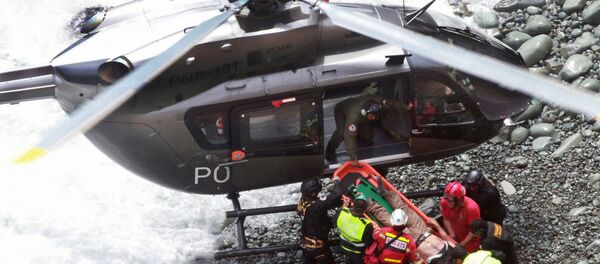In this photo provided by the government news agency Andina, rescue workers load an injured man on a stretcher after he was retrieved from a bus that fell off a cliff after it was hit by a tractor-trailer rig, in Pasamayo, Peru, Tuesday, Jan. 2, 2018. - Sputnik International