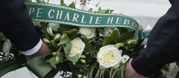 French police officers hold a wreath of flowers before a ceremony outside the kosher grocery where Amedy Coulibaly killed four people, during the third anniversary of the attack, in Paris, Sunday, Jan. 7, 2018 - Sputnik International
