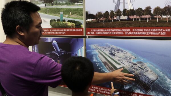 In this Thursday, July 27, 2017, file photo, a man and a child look at a picture showing the Fiery Cross Reef in the Spratly islands, in the disputed South China Sea, on display at the military museum in Beijing - Sputnik International
