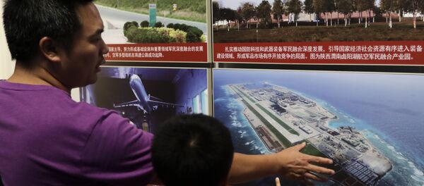 In this Thursday, July 27, 2017, file photo, a man and a child look at a picture showing the Fiery Cross Reef in the Spratly islands, in the disputed South China Sea, on display at the military museum in Beijing In this Thursday, July 27, 2017, file photo, a man and a child look at a picture showing the Fiery Cross Reef in the Spratly islands, in the disputed South China Sea, on display at the military museum in Beijing - Sputnik International