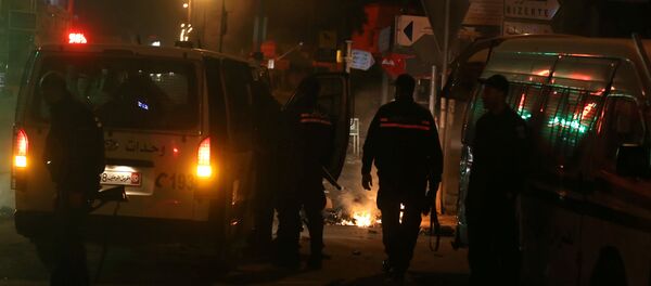 Police vehicles stop in front of burning tires set up by protesters during demonstrations against rising prices and tax increases, in Tunis, Tunisia - Sputnik International