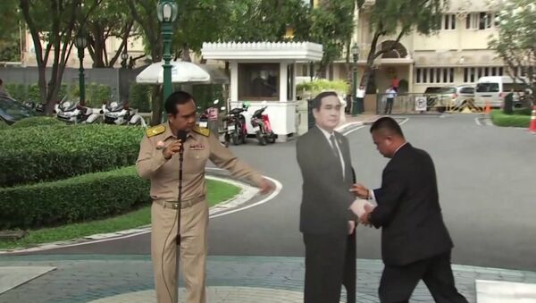 In this image from video, Thailand's Prime Minister Prayuth Chan-ocha, left, directs the scene as a life-sized cardboard cut-out figure of himself is carried into view by an aid, in Bangkok, Thailand, Monday Jan. 8, 2018. - Sputnik International