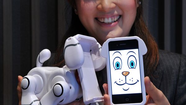 An employee of Japanese toy manufacturer Bandai displays a new virtual pet robot Smart Pet, which is used to dock iPhones or iPods at a press preview in Tokyo. (File) - Sputnik International