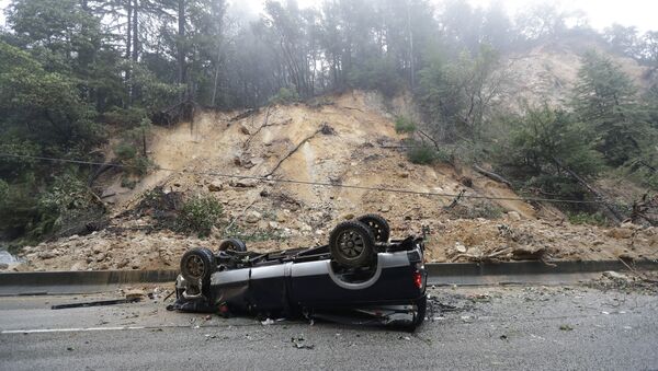 An overturned vehicle blocks a south bound lane next to a mudslide on Highway 17 Tuesday, Feb. 7, 2017, south of Santa Cruz, Calif. - Sputnik International