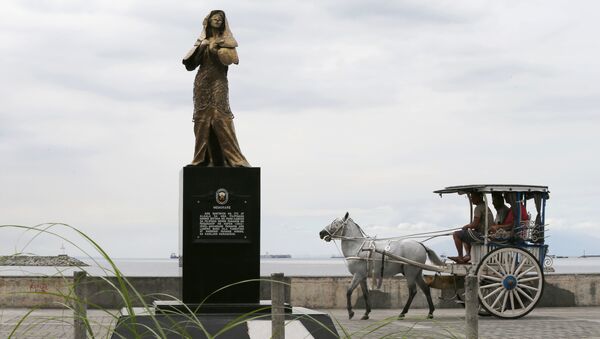 A horse-drawn cart, catering to tourists, passes by a statue of a Comfort Woman or Filipino sex slaves during WWII, which was erected along a scenic Baywalk in Manila, Philippines Thursday, Jan. 11, 2018 - Sputnik International