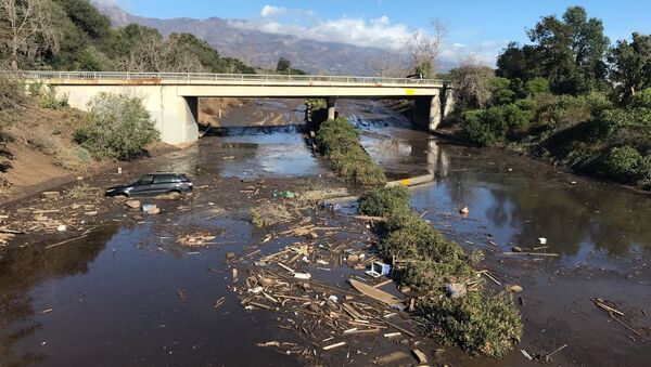 An abandoned car is seen stuck in flooded water on the 101 freeway after a mudslide in Montecito, California, U.S. January 10, 2018 - Sputnik International