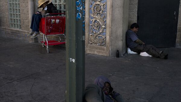 Three homeless people take a nap on a sidewalk in the Skid Row area of downtown Los Angeles - Sputnik International