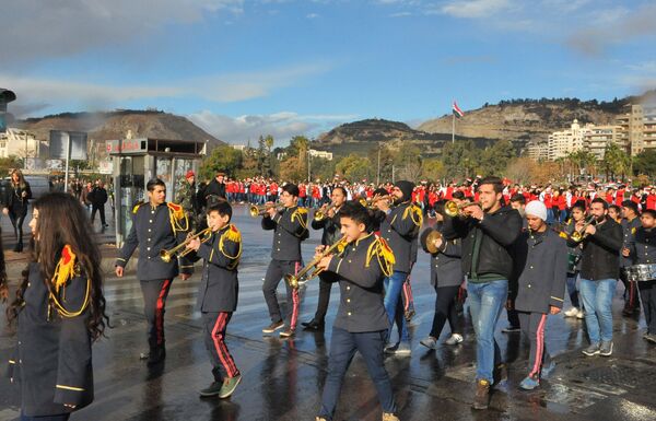 A procession of students, led by a marching band, proceeds to the center of the Syrian capital following the conclusion of the Scientific Olympiad. A procession of students, led by a marching band, proceeds to the center of the Syrian capital following the conclusion of the Scientific Olympiad. - Sputnik International