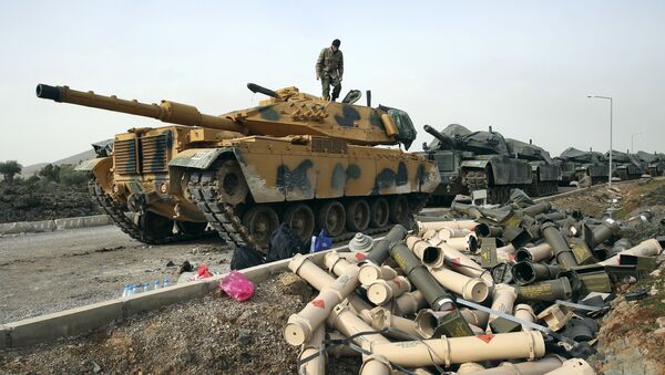 Turkish Army soldiers prepare their tanks next to empty shells at a staging area in the outskirts of the village of Sugedigi, Turkey, on the border with Syria, Monday, Jan. 22, 2018 - Sputnik International