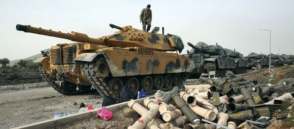 Turkish Army soldiers prepare their tanks next to empty shells at a staging area in the outskirts of the village of Sugedigi, Turkey, on the border with Syria, Monday, Jan. 22, 2018 - Sputnik International