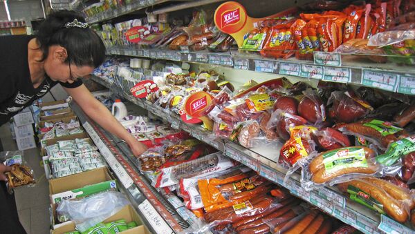 A woman chooses from a selection of pork sausages at a local grocery stall, Tuesday Sept. 11, 2007 in Beijing, China - Sputnik International