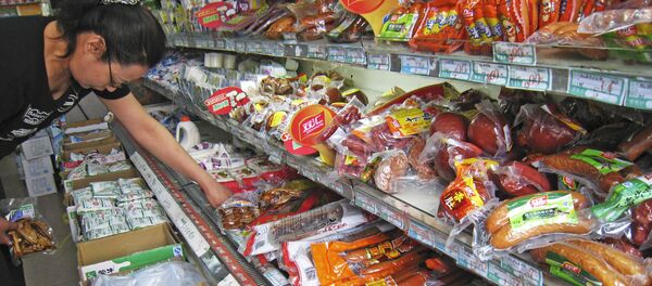 A woman chooses from a selection of pork sausages at a local grocery stall, Tuesday Sept. 11, 2007 in Beijing, China - Sputnik International