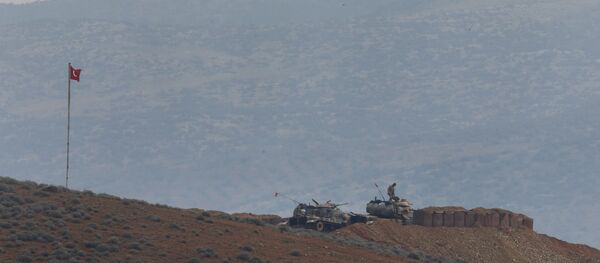 Soldiers man a Turkish Army artillery position, as seen from the outskirts of the village of Sugedigi, Turkey, near the border with Syria, background - Sputnik International