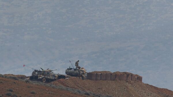 Soldiers man a Turkish Army artillery position, as seen from the outskirts of the village of Sugedigi, Turkey, near the border with Syria, background - Sputnik International