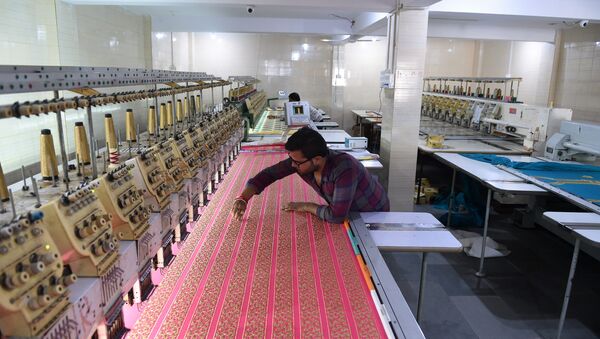An Indian textile maker works on an embroidery machine at a workshop in Ahmedabad. (File) - Sputnik International