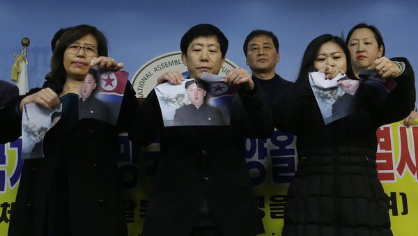 North Korean defectors tear portraits of North Korean leader Kim Jong Un during a press conference against the North Korea's participation in the 2018 Pyeongchang Winter Olympics at the National Assembly in Seoul, South Korea, Wednesday, Jan. 24, 2018 - Sputnik International