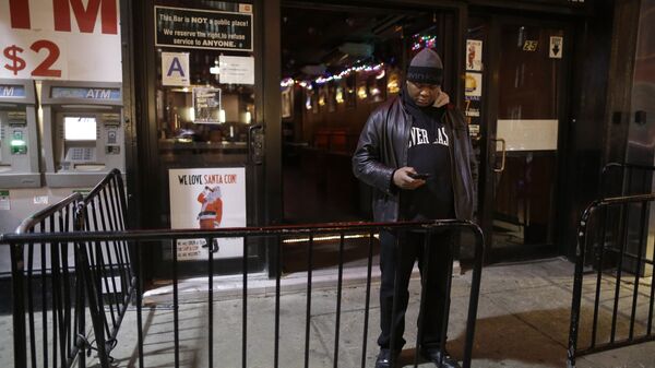 In this Wednesday, Dec. 9, 2015, photo a bouncer stands next to a sign professing love for Santacon hanging in the window of the Continental bar in New York - Sputnik International